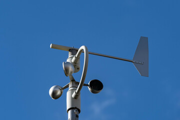 Girouette indiquant la direction du vent sur fond de ciel bleu