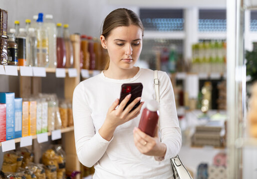 Young woman scanning qr code for red smoothie