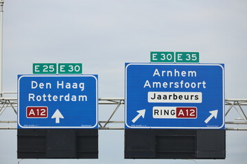 Blue direction sign junction to A12 Rotterdam and Den Haag and Arnhem