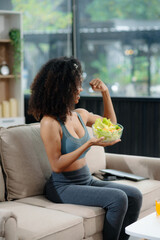 Woman enjoys a fresh salad with fruits and juice, embodying wellness, nutrition, and vitality