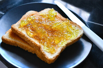 Toast with lemon and lime marmalade jam on a plate. Lovely breakfast at home.