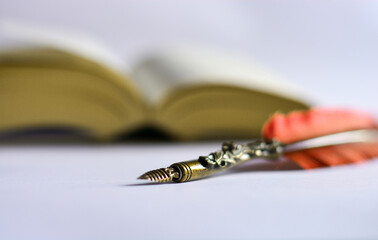 a red pen and an old book on a white table