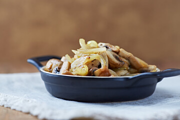 Onion with mushrooms. Rustic wooden background. 