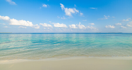 Obraz premium Peaceful empty sunny beach closeup view soft golden sand gentle sea waves. Sunshine blue sky clouds. Tranquil seascape horizon. Relaxing tropical shore escape. Inspire nature beauty summer vacation