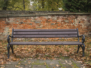 Old bench in front of a wall in autumn