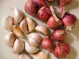Fresh Garlic Cloves and Red Shallots on a Surface