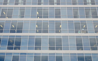 Generic office building exterior with sky reflected in glass windows