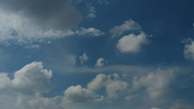 Bright blue sky scattered with soft, fluffy clouds forming dynamic shapes, creating a peaceful and open atmosphere ideal for sky-gazing or weather observation.