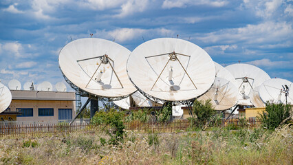 Close-up view of multiple large satellite dishes at a ground telecommunication station
