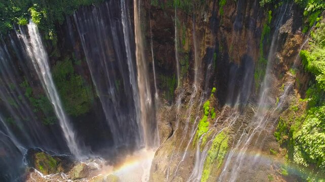 beautiful waterfall Coban Sewu in tropical forest, Java Indonesia. aerial view tumpak sewu waterfall in rainforest aerial footage