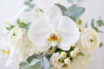 Obraz premium A stunning white orchid dominates a beautiful arrangement of fresh, delicate flowers.