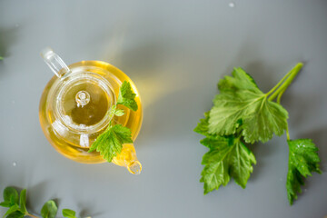 Aromatic drink from mint and currant leaves in a teapot and cup