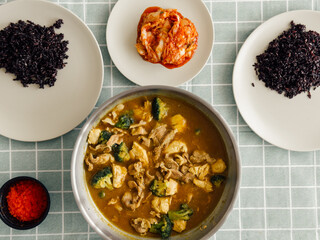 Thai curry and rice with vegetables on tiled table