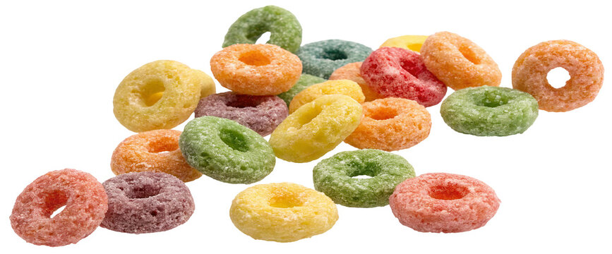 A close up shot of a pile of colorful fruit flavored cereal rings on a black background in a studio shot