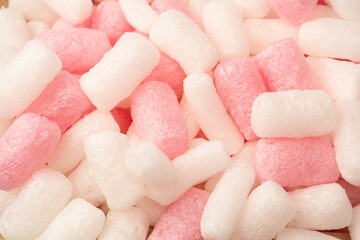 Pink and white box filler as a background. Top view.