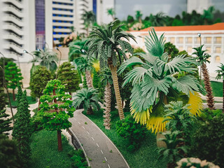 Artificial palms and other decorative trees along the asphalt road - a model depicting a city street.
