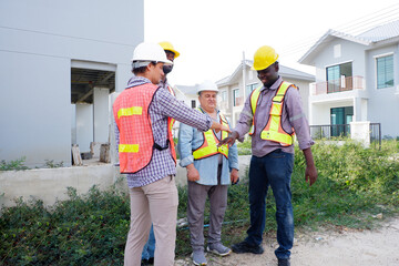 A male engineer wearing a safety helmet is walking to inspect the construction site — an engineer...