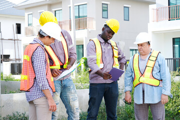 A male engineer wearing a safety helmet is walking to inspect the construction site — an engineer...