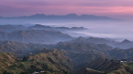 Fototapeta premium The mountains are covered in fog and the sky is a beautiful pink color