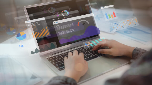 Close-up of hands using laptop with holographic data dashboard and analytics charts. Modern technology concept for big data analysis, business intelligence, and digital transformation.