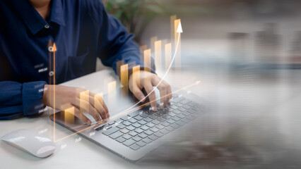 Businessperson analyzing financial growth with monthly bar chart and upward trend line on laptop. Concept of business analytics, performance tracking, and data-driven strategy.