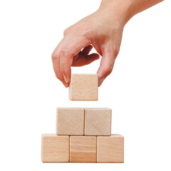 Hand holding square blank wooden cube block while stacking into a pile. Isolated cutout in transparent background.