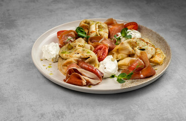 Thin savory pancakes with prosciutto and cream cheese, tomatoes and herbs. Dinner or lunch. Cooking and serving dishes.