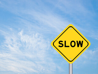 Yellow transportation sign with word slow on blue color sky background