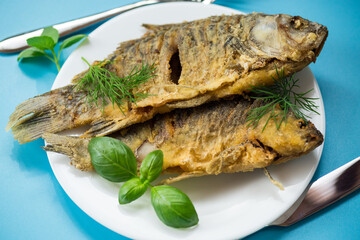Appetizing fried crucian carp with butter and spices in a frying pan