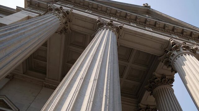 Classical building with tall Corinthian columns shot from low angle under clear sky