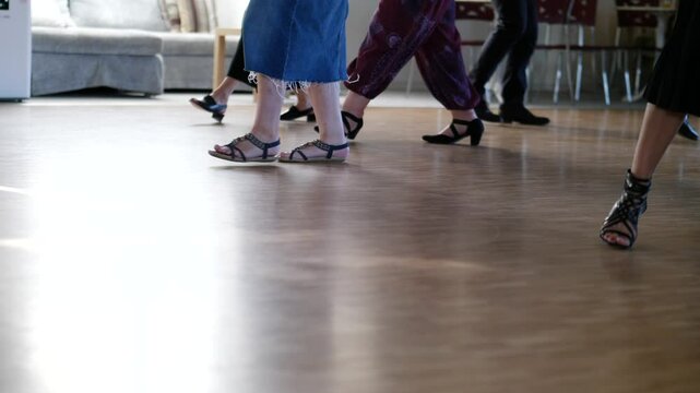Low angle slow-motion of the feet of dancers while they are training in a dancing class