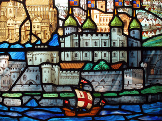 Tudor galleon sailing past the Tower of London on a stained glass window at the early medieval church of All Hallows by the Tower, London England, travel stock photo image