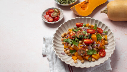 Fresh chickpea and pumpkin salad with tomatoes and herbs for healthy eating. Copy space