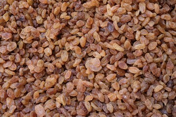Natural dried raisins background in natural light - organic food texture