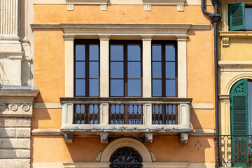 Classic Mediterranean Building Facade with Stone Balcony and Orange Stucco Walls