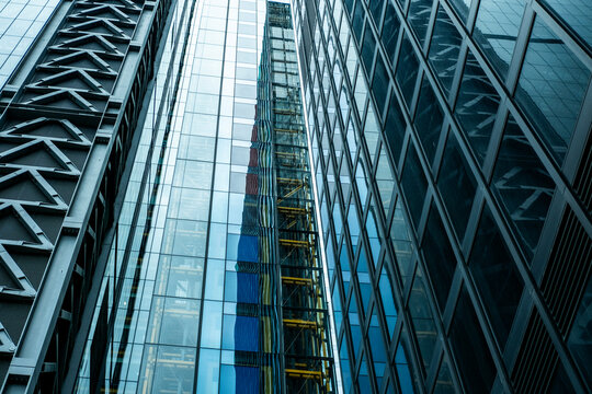 Modern glass facade with steel structures and reflections in London cityscape, ideal for business, architecture, and urban development stock imagery.