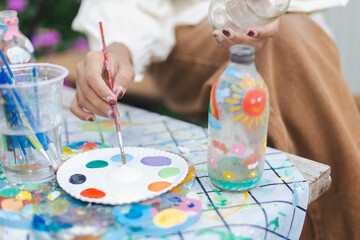 Sustainable and ecofriendly craft activity involving painting on glass bottle with bright colors...