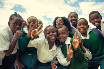 Real photo of happy black African kids in school uniforms, smiling and enjoying a break. A positive image of youth, education, diversity, and community spirit.