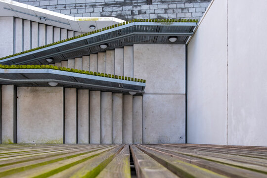 Contemporary architectural facade with linear elements and green rooftop, minimalist geometry and rhythm for architecture, design and urban development themes.