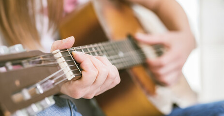 Close-Up Hands Playing Acoustic Guitar with Fingertips on Fretboard and Strings