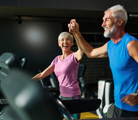 Portrait of a senior woman exercising in a gym, mature couple running using threadmill machine equipment, healthy lifestyle and cardio exercise at fitness club concepts, vitality and active senior, co