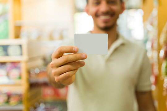 Smiling customer showing fidelity card in grocery store