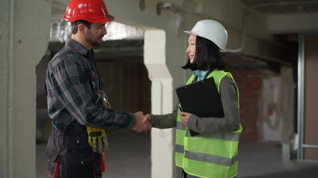 Business builders handshake Japanese Caucasian engineers shaking hands partnership colleagues workers woman man discussing build project agreement greeting gesture cooperate teamwork constructors site