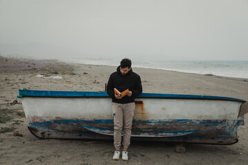 Student Reads His Notes By The Sea During A Winter Day