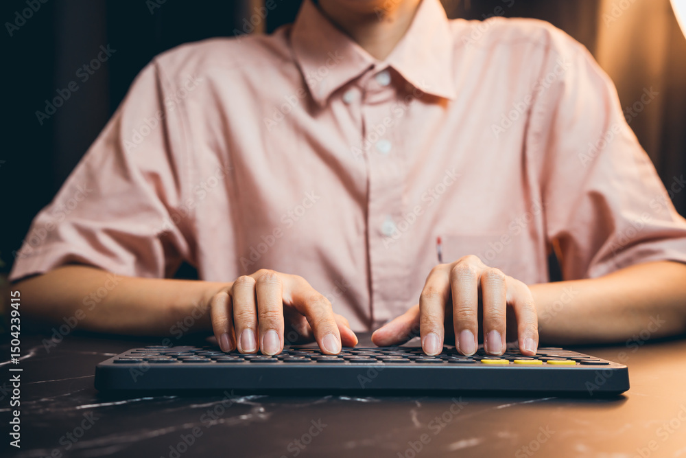 Poster close-up view of hands typing on a modern keyboard in a cozy workspace with soft lighting at night