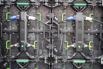 Close-up view of the rear side of modular LED display panels connected with power and signal...