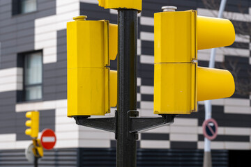 Close-up of yellow traffic lights against black and white striped facade, strong contrast and geometry, ideal for design, architecture and city infrastructure imagery.