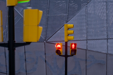 Red traffic lights in front of a textured urban wall, minimalist geometry and vibrant color in city infrastructure, ideal for design and visual identity stock.
