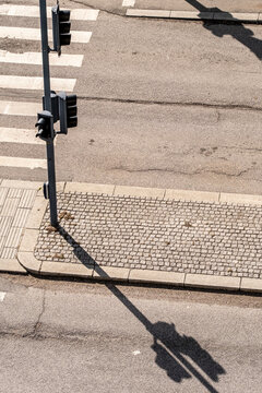 Traffic lights and street shadows on asphalt, minimalist composition, lines and contrast in urban infrastructure, ideal for visual design, background and business use.