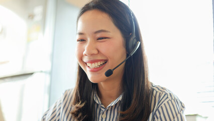 close up call center employee woman smile with happy while working on desktop to check about task...
